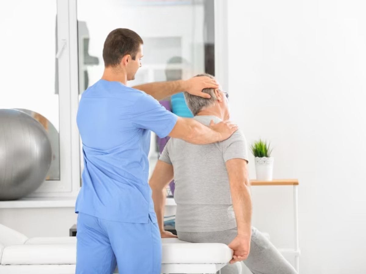 Physiotherapist discussing BGREEN vibration therapy equipment with patient